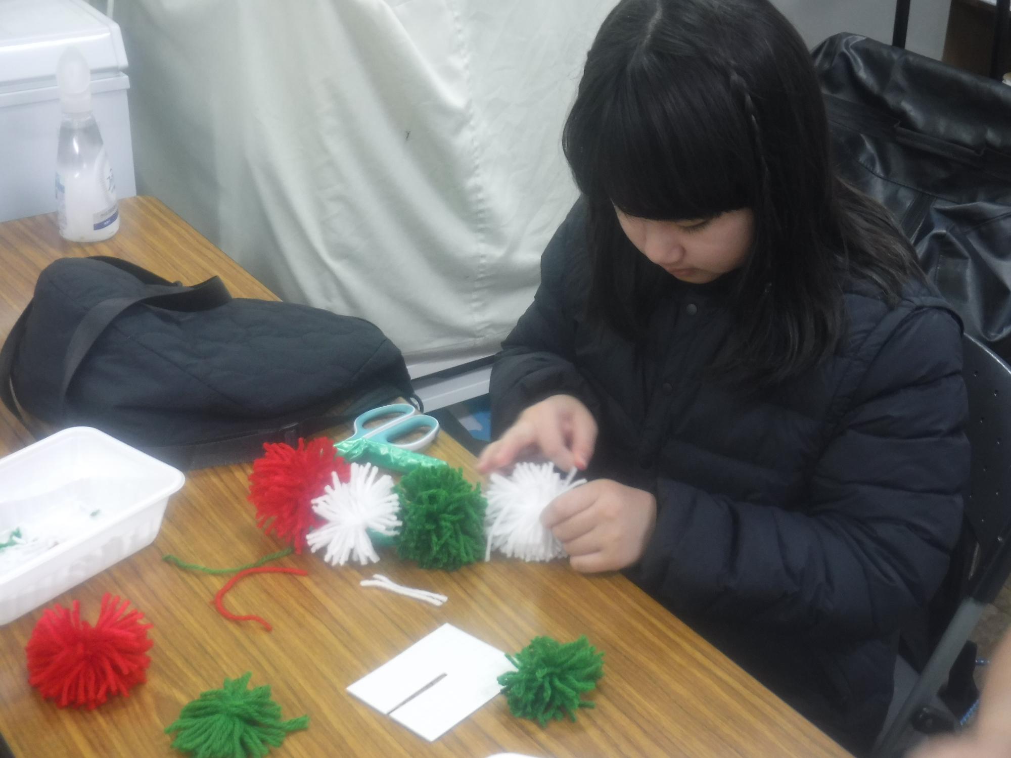 毛糸を使ってボンボンを作っている様子