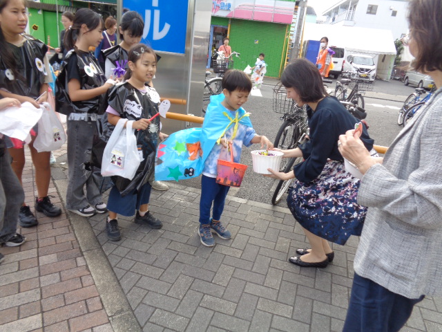 冨士見商事さんでお菓子やシールをもらっている