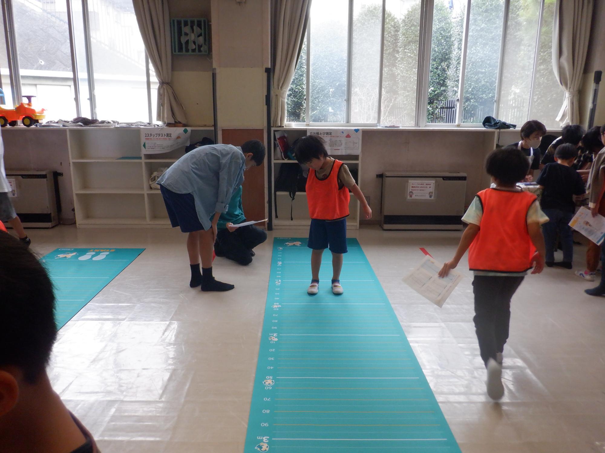 立ち幅跳びを測定中の小学生
