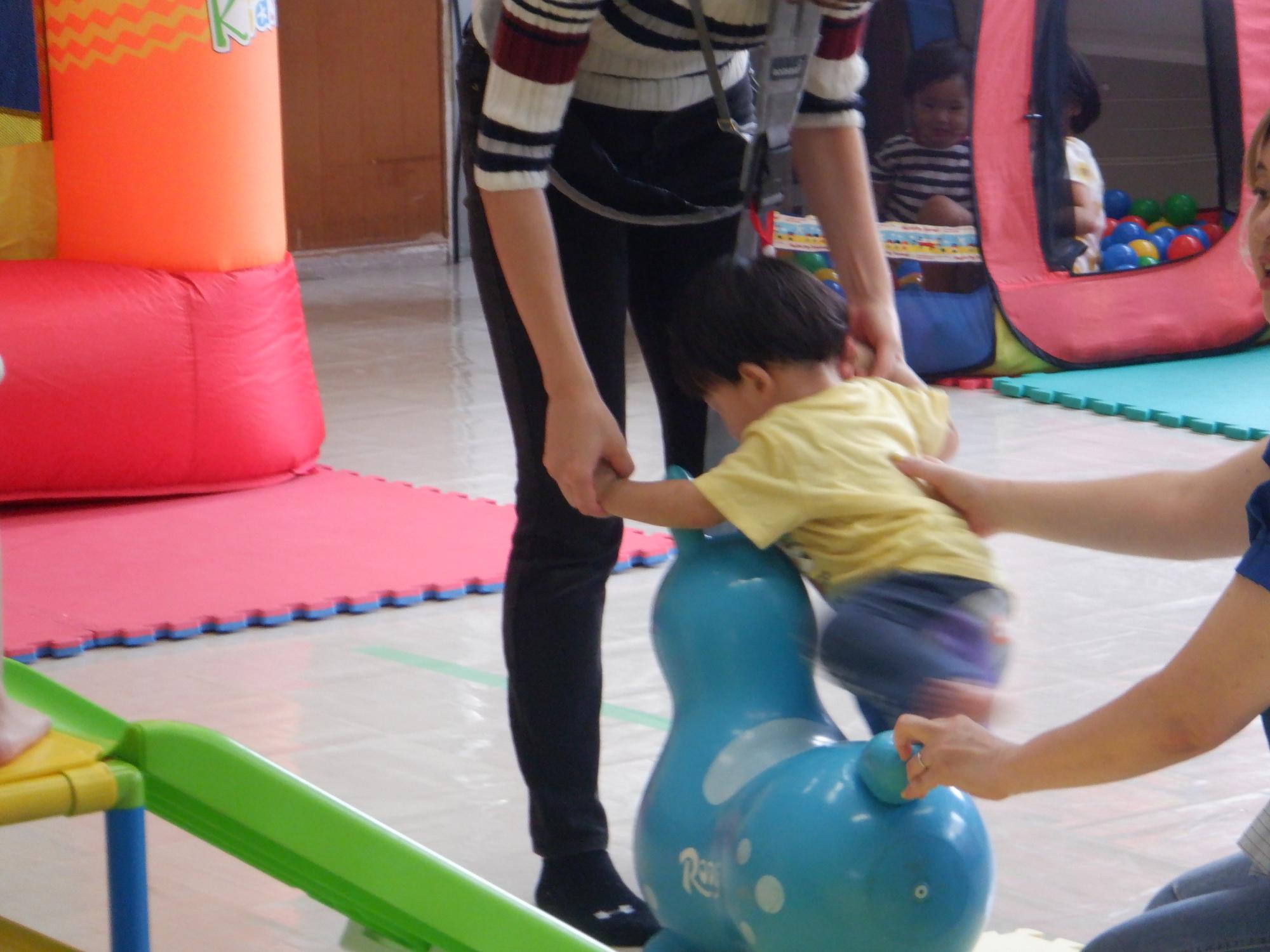 乗り物遊具で遊ぶ幼児