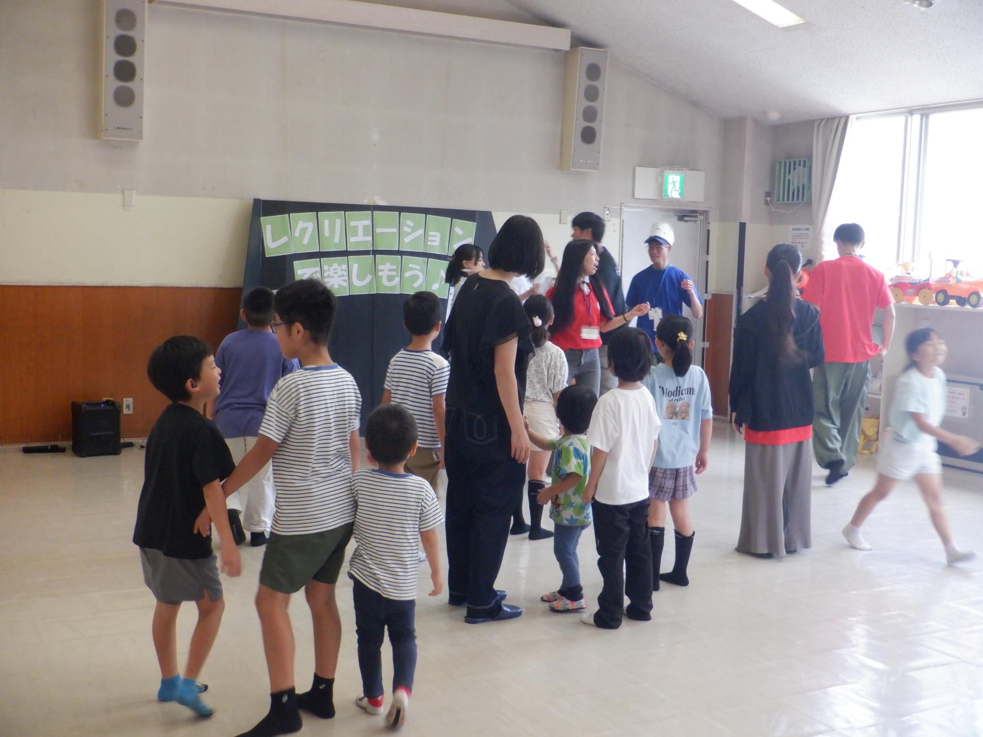 レクリエーションを楽しんでいる児童と幼児親子