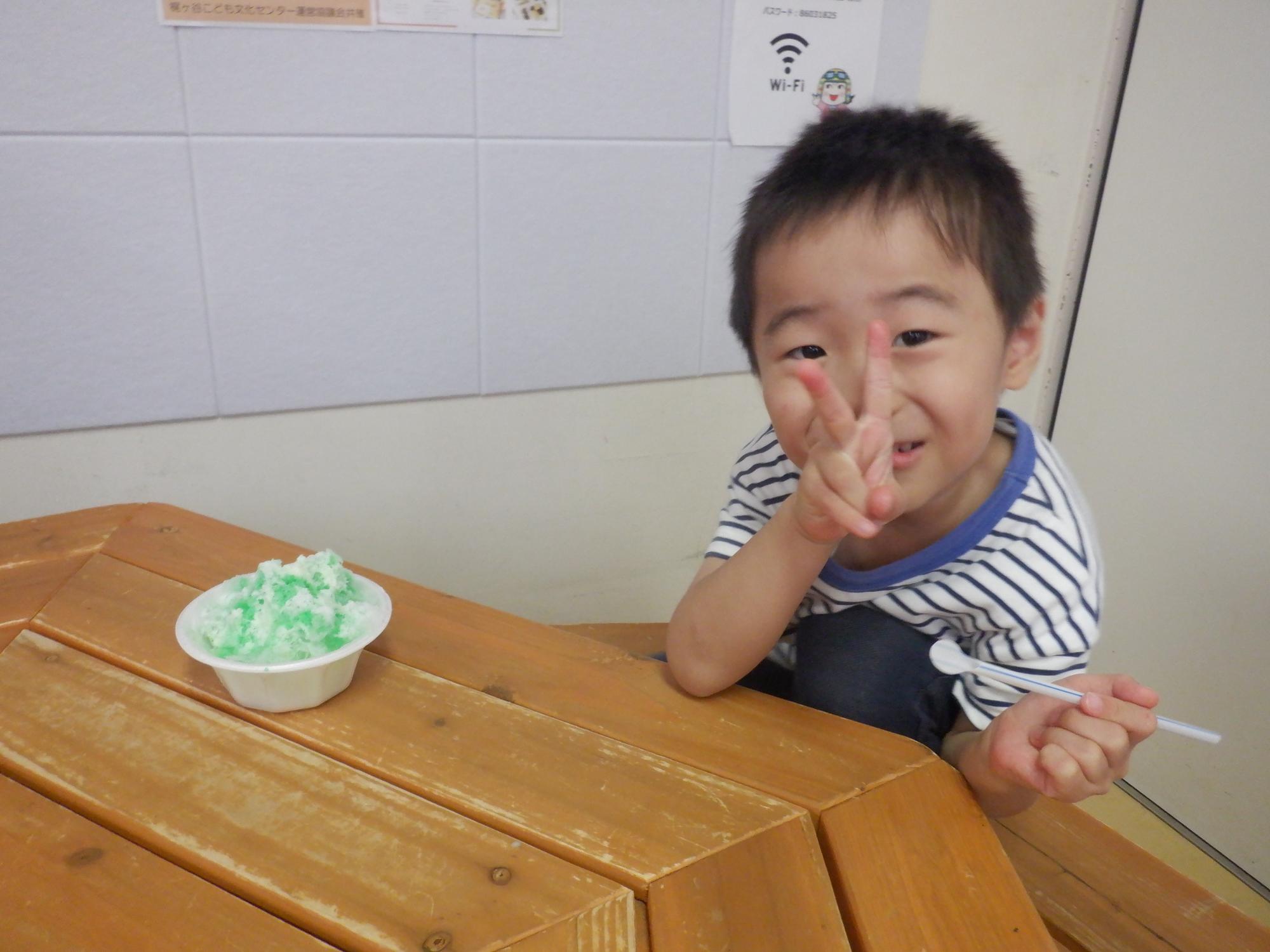 嬉しそうにかき氷を食べる幼児