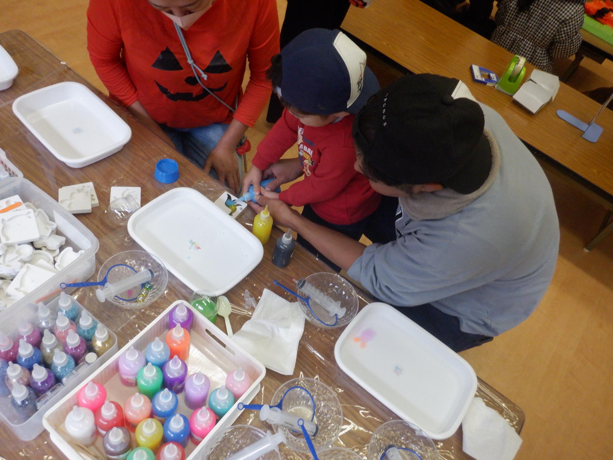 うぉーたーぷにぷにを作成している幼児親子の写真