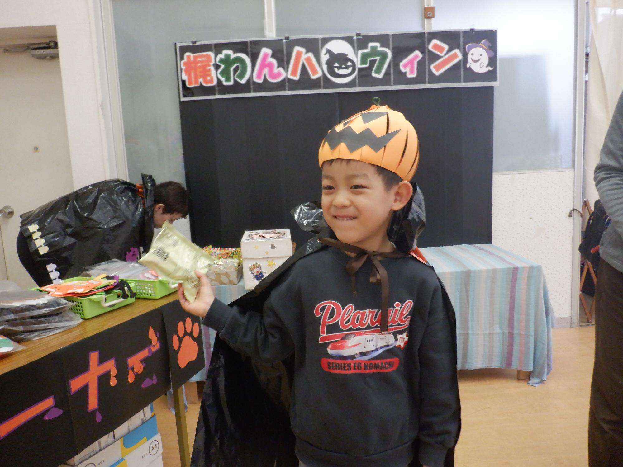 出来上がった手作りかぼちゃ帽子をかぶる男の子