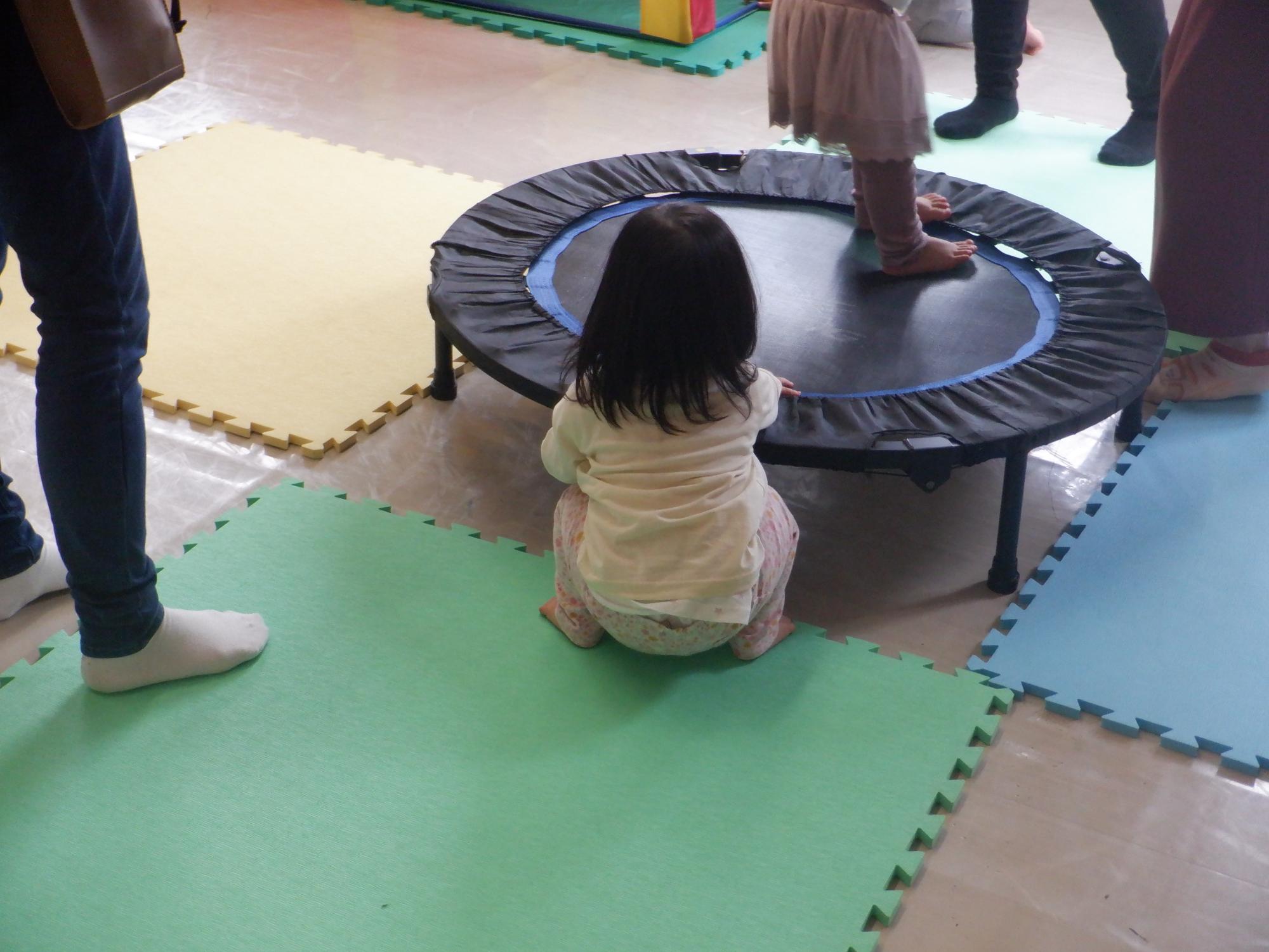 トランポリンの順番を待っている幼児の後ろ姿