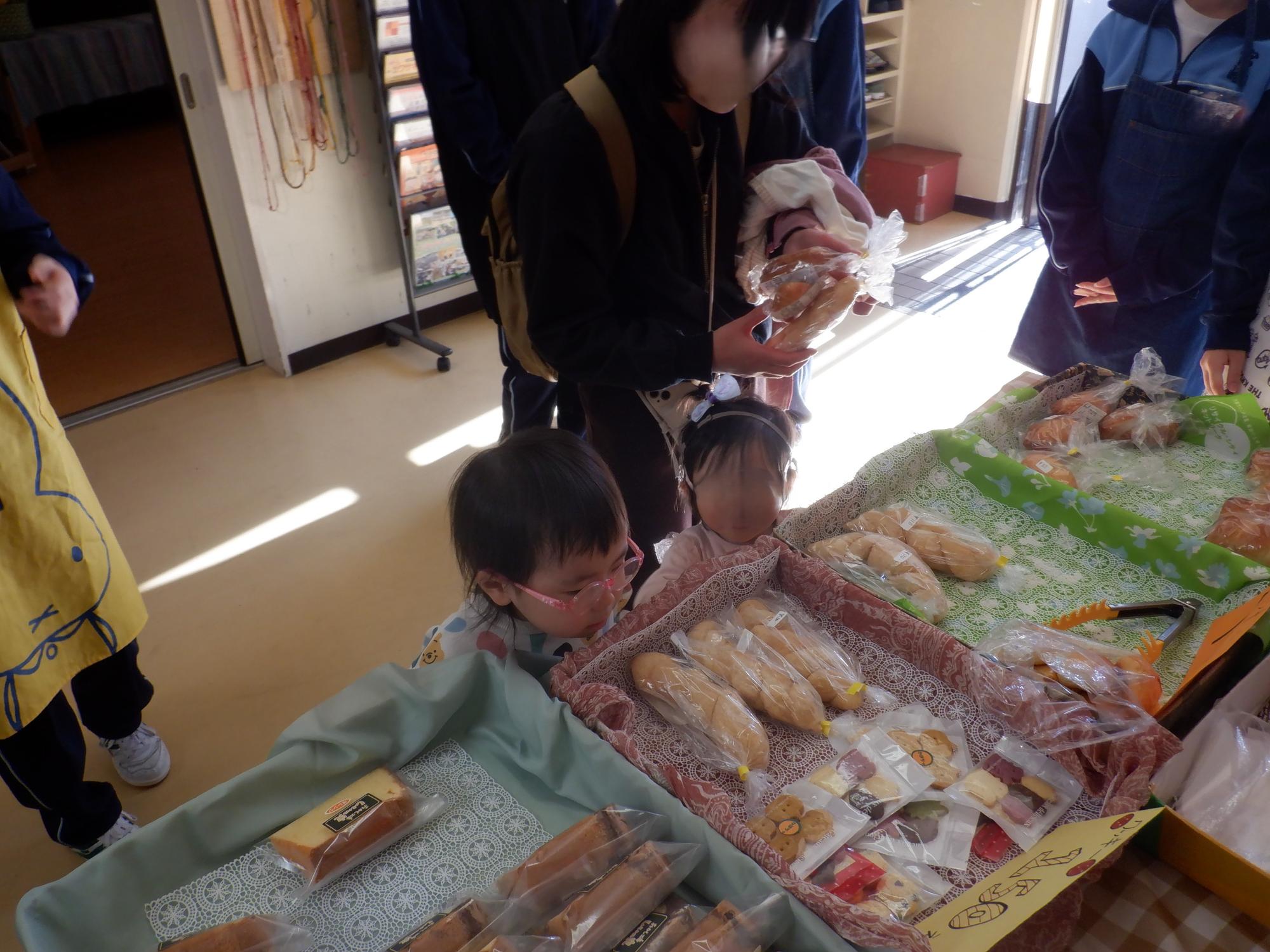 並んでいるパンを楽しそうにアラブ幼児たち