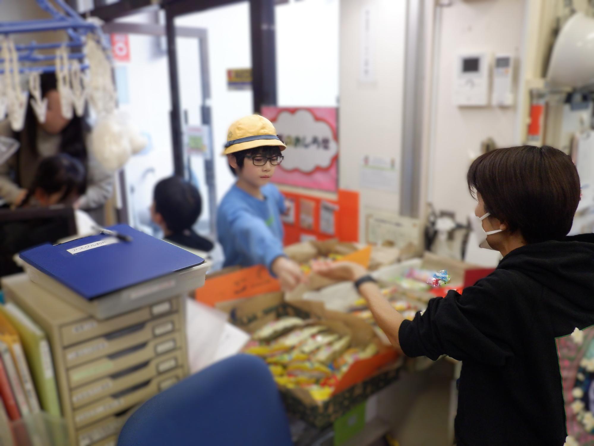 だがしの受け渡しをしている小学生の様子