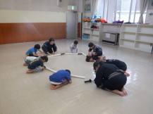 円状に広がり正座で礼をする先生と子供たちの写真