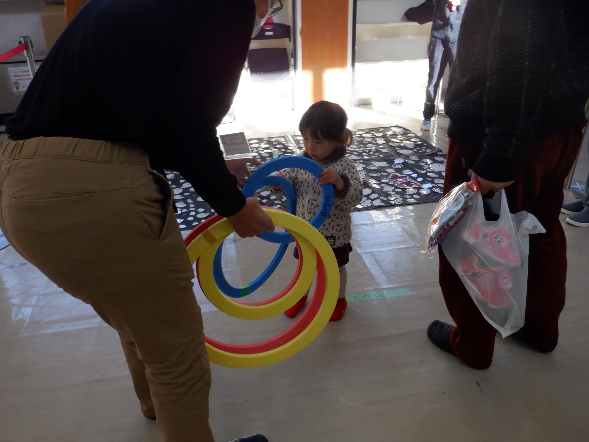 投げ輪を受け取る幼児の写真