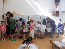 大勢の子供たちが並んだロッカーの前で話をする写真