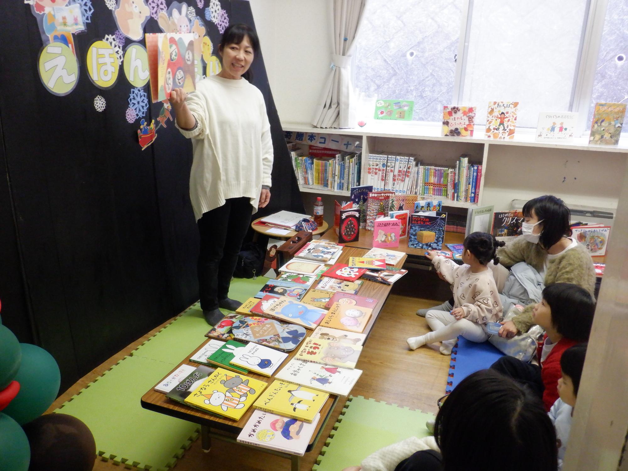 絵本を読む先生と話を聞く幼児達