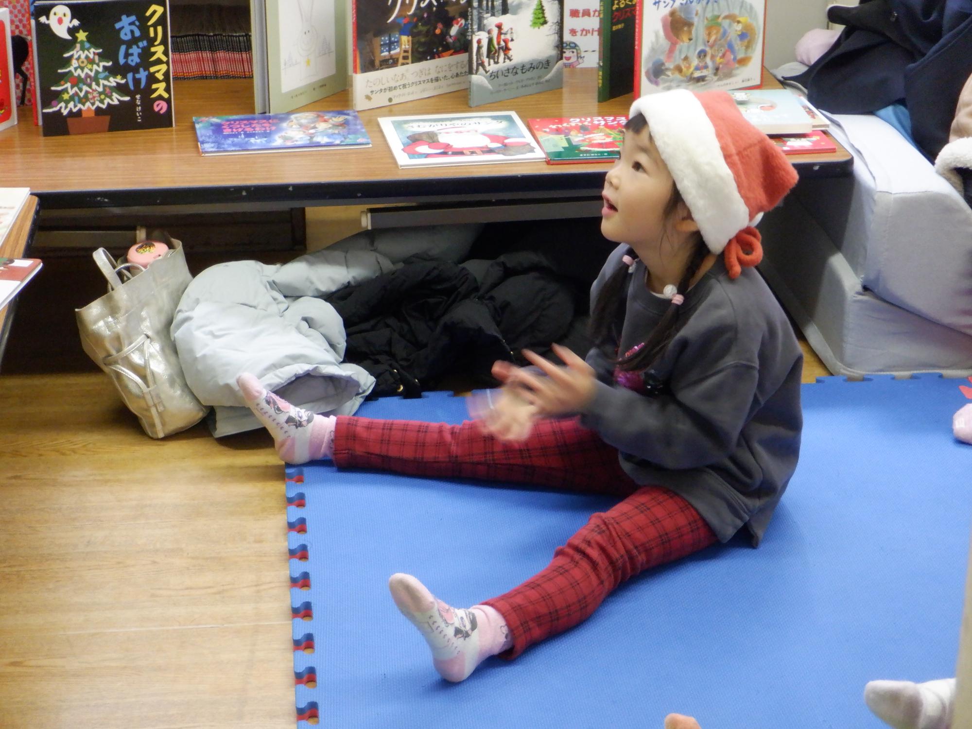 最前列で絵本をみる幼児の写真