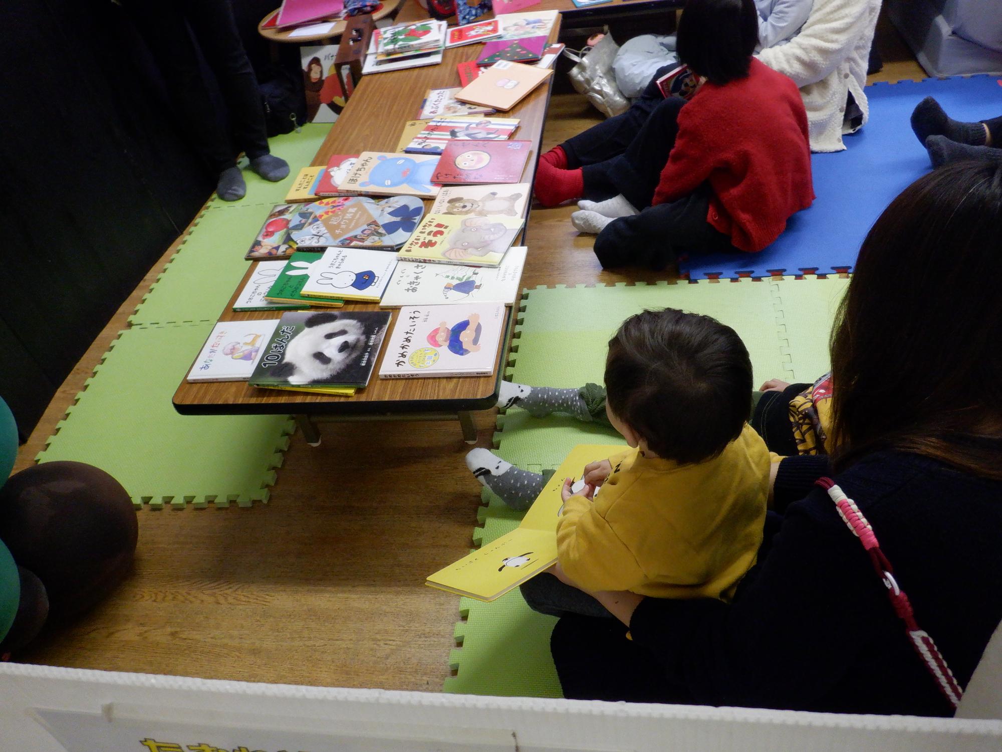並んである絵本に興味をもつ幼児の様子