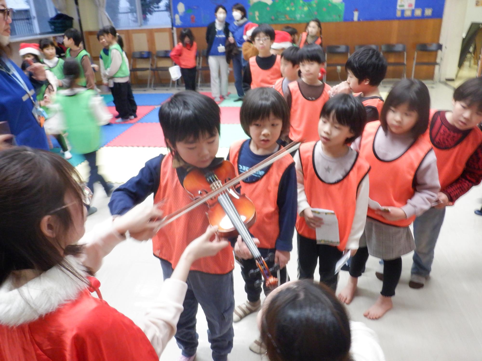バイオリンの楽器体験をする小学生