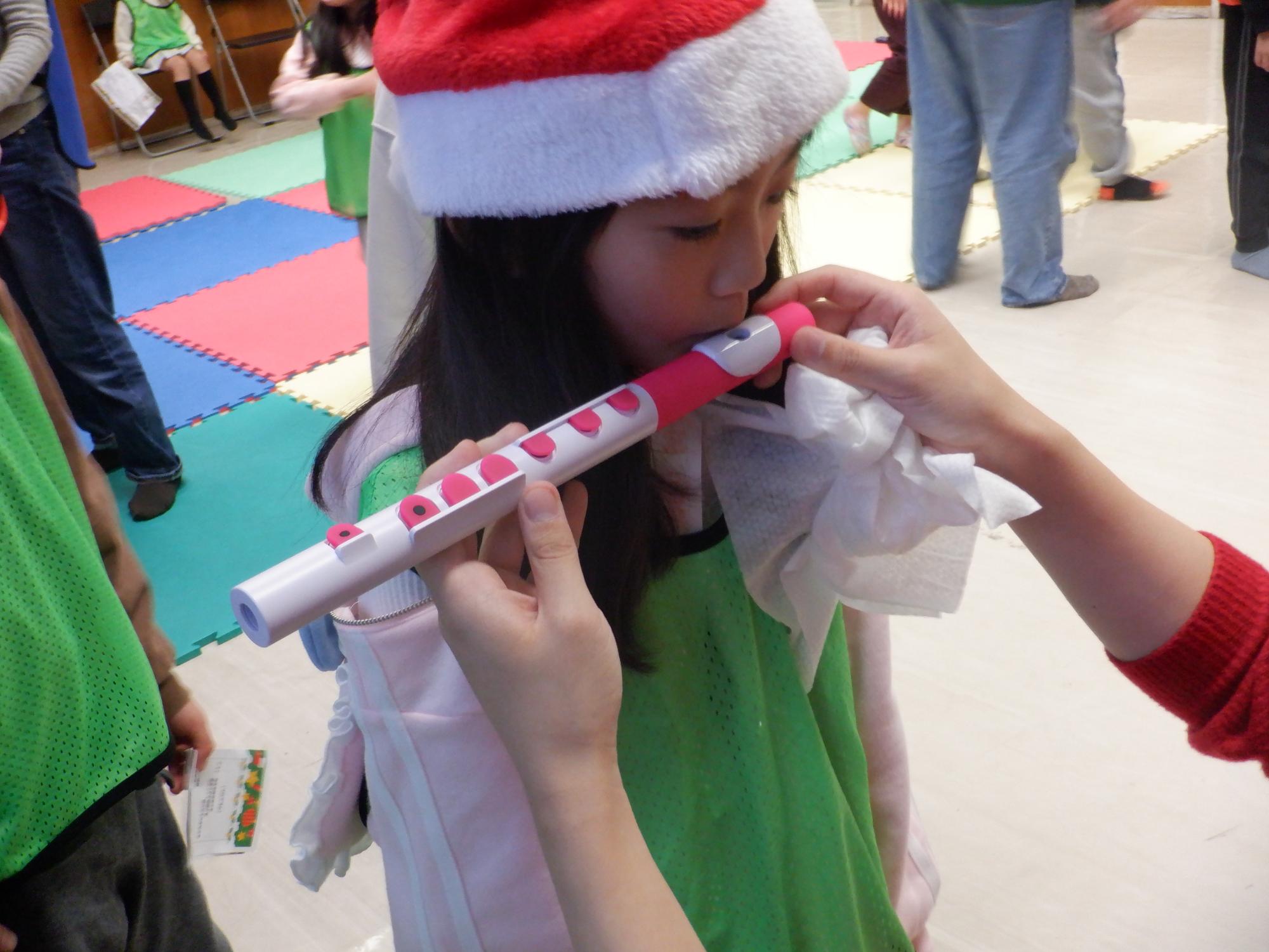 フルートの楽器体験をする小学生