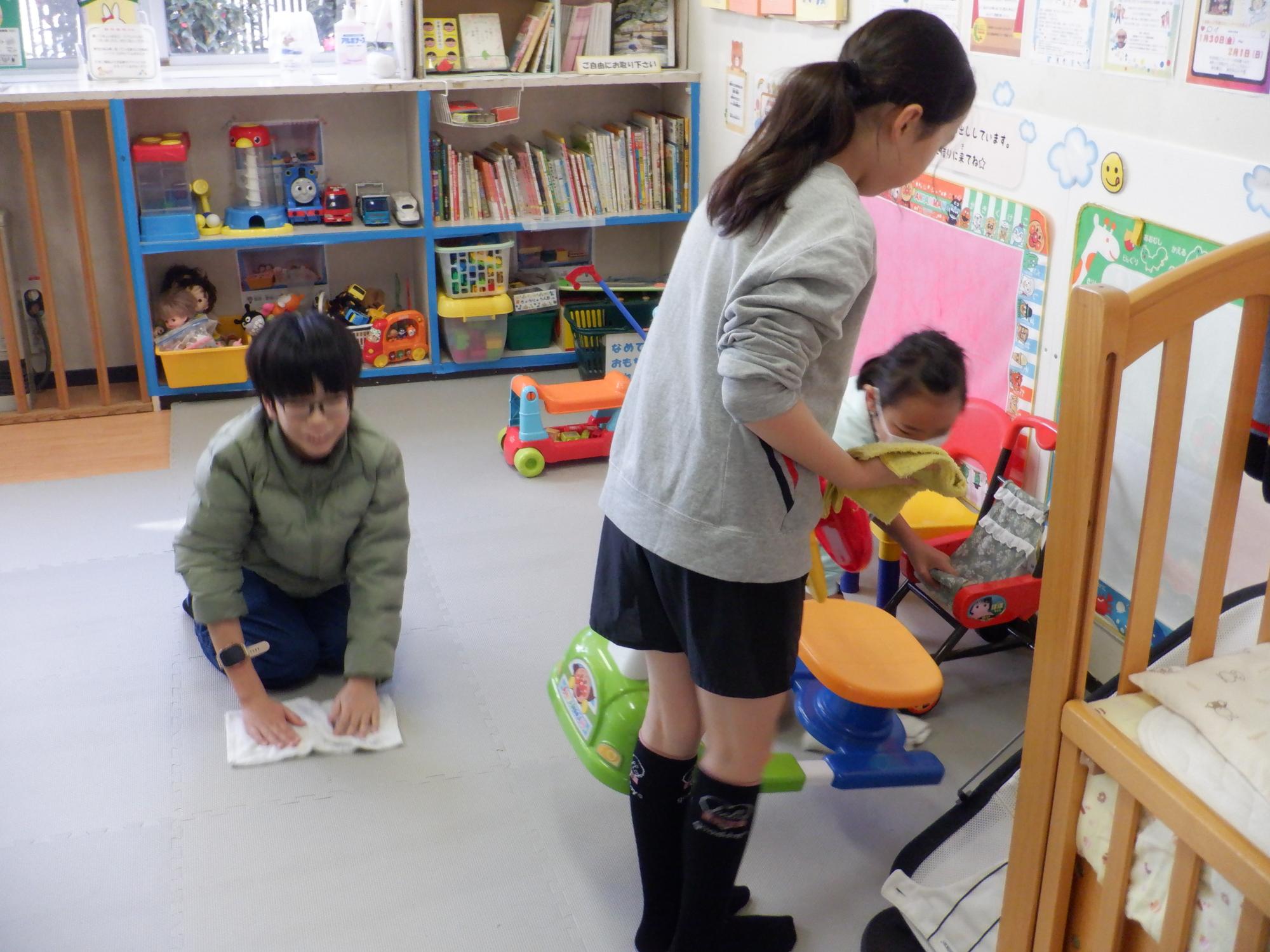 幼児室の壁やマットを掃除する様子