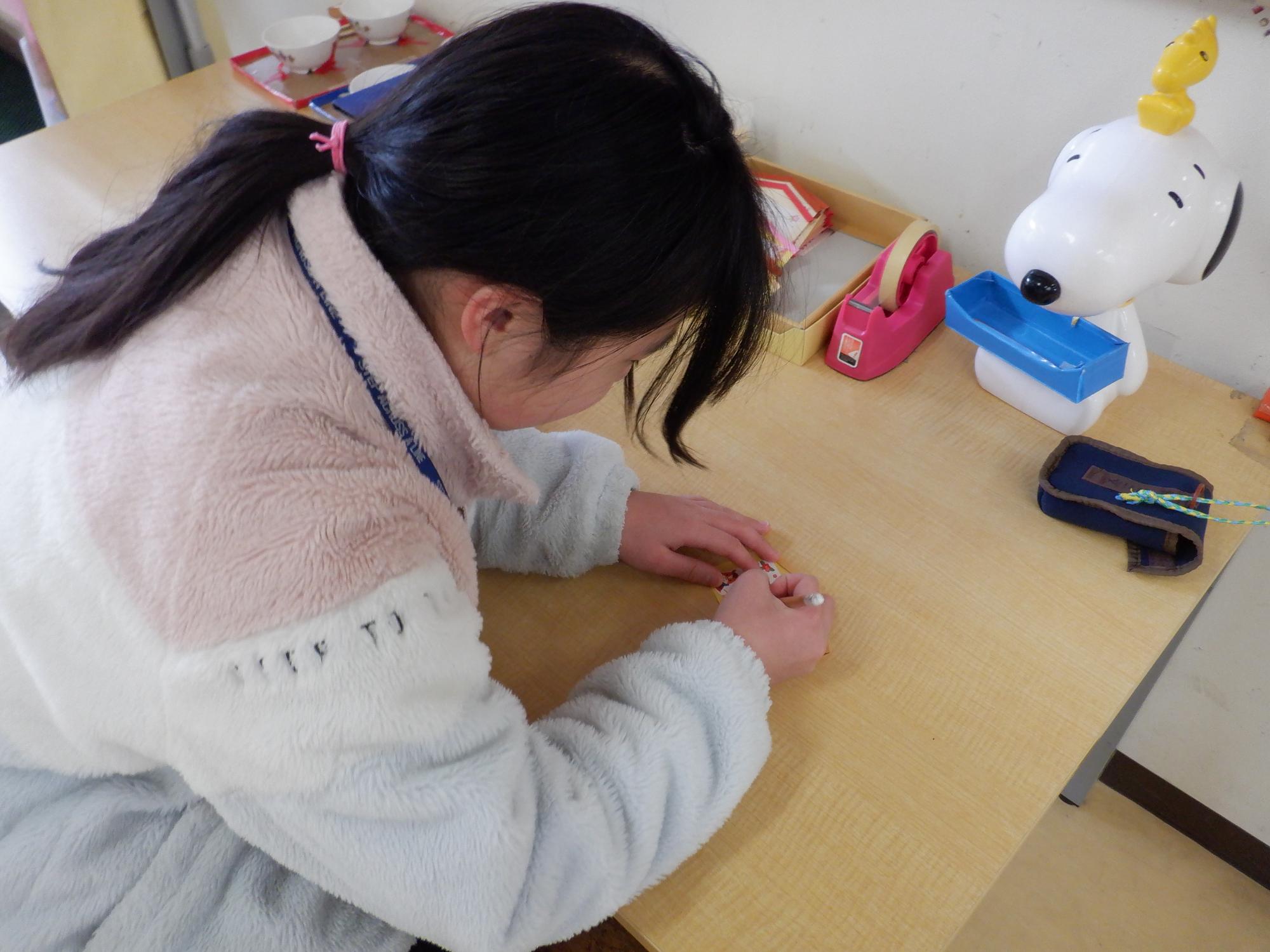 絵馬に願い事かく小学生の姿