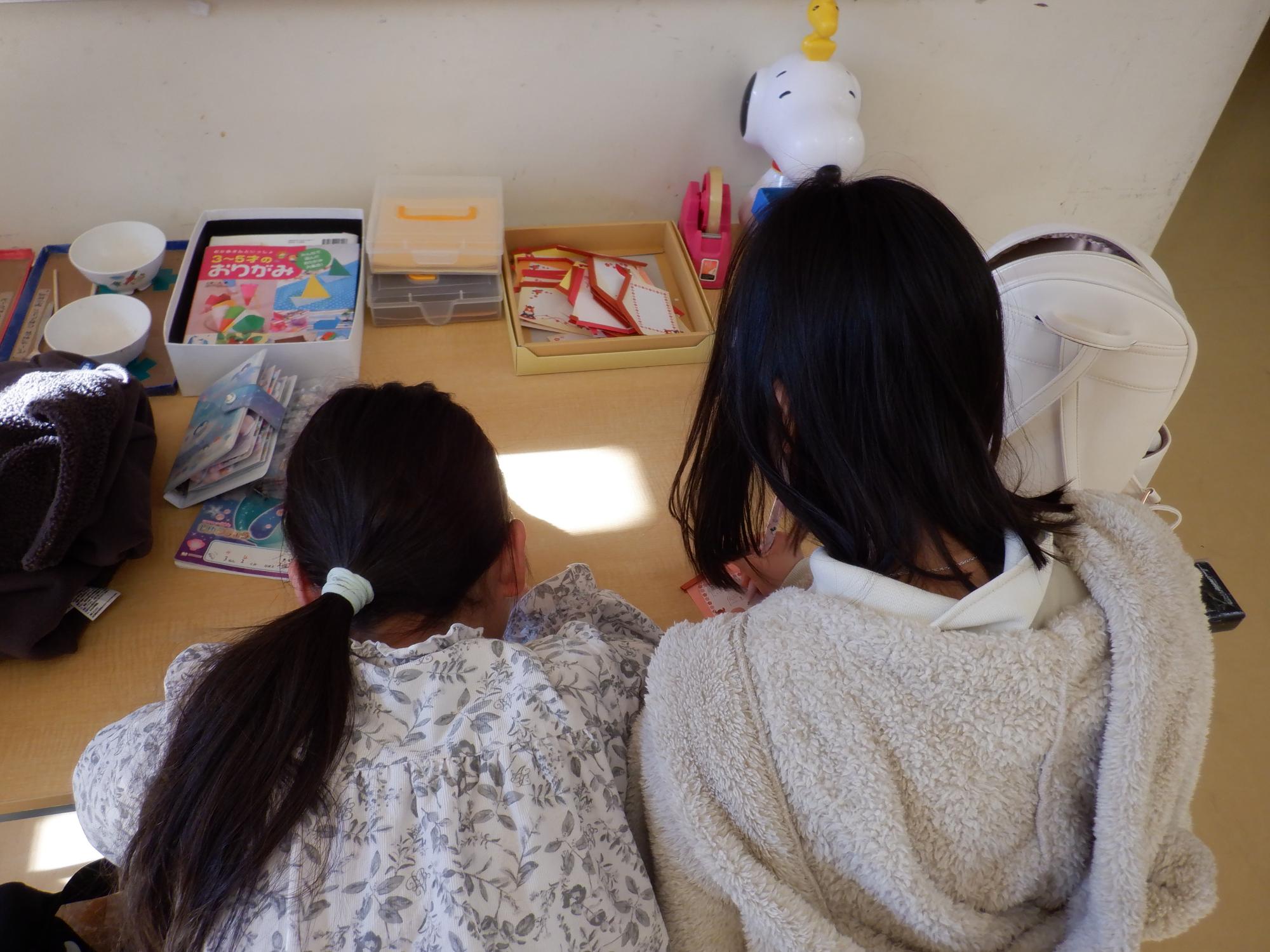 真剣に絵馬を書く小学生の後ろ姿