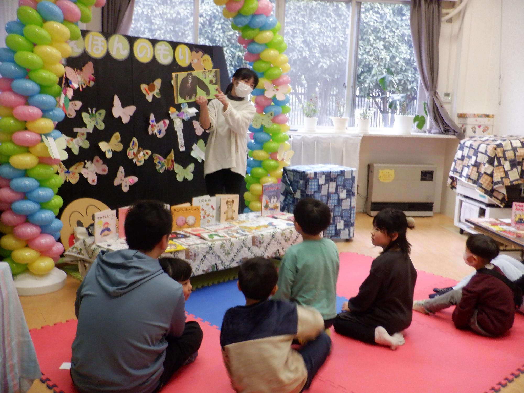 絵本を読む先生と話を聞く幼児達