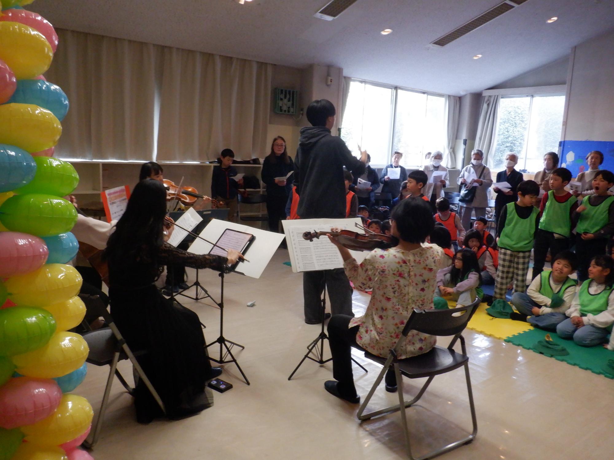 中学生の指揮に合わせ参加者全員で合唱している様子