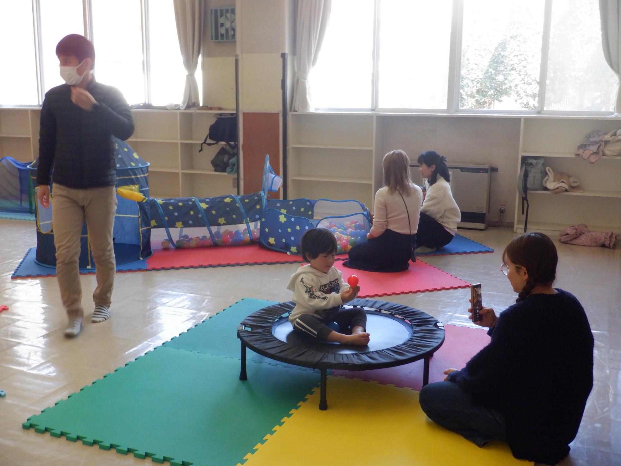 トランポリンの上で撮影する親子