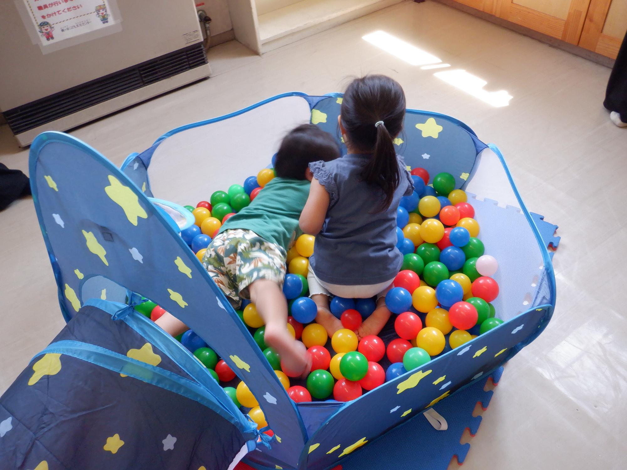 ボールプールで泳ぐ幼児達