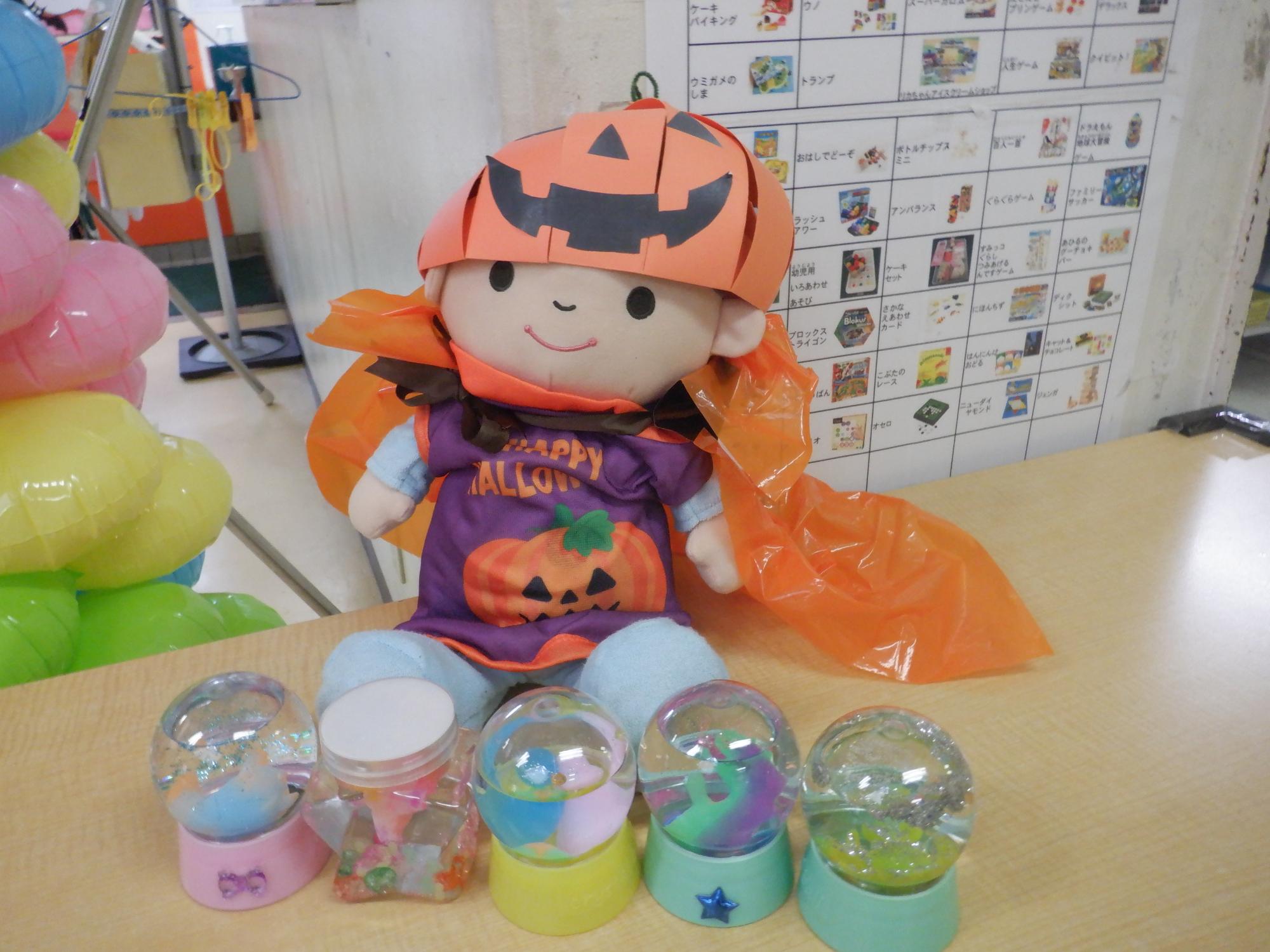 うぉーたーぷにぷにと手作り帽子と一緒に写る赤ちゃんの人形写真