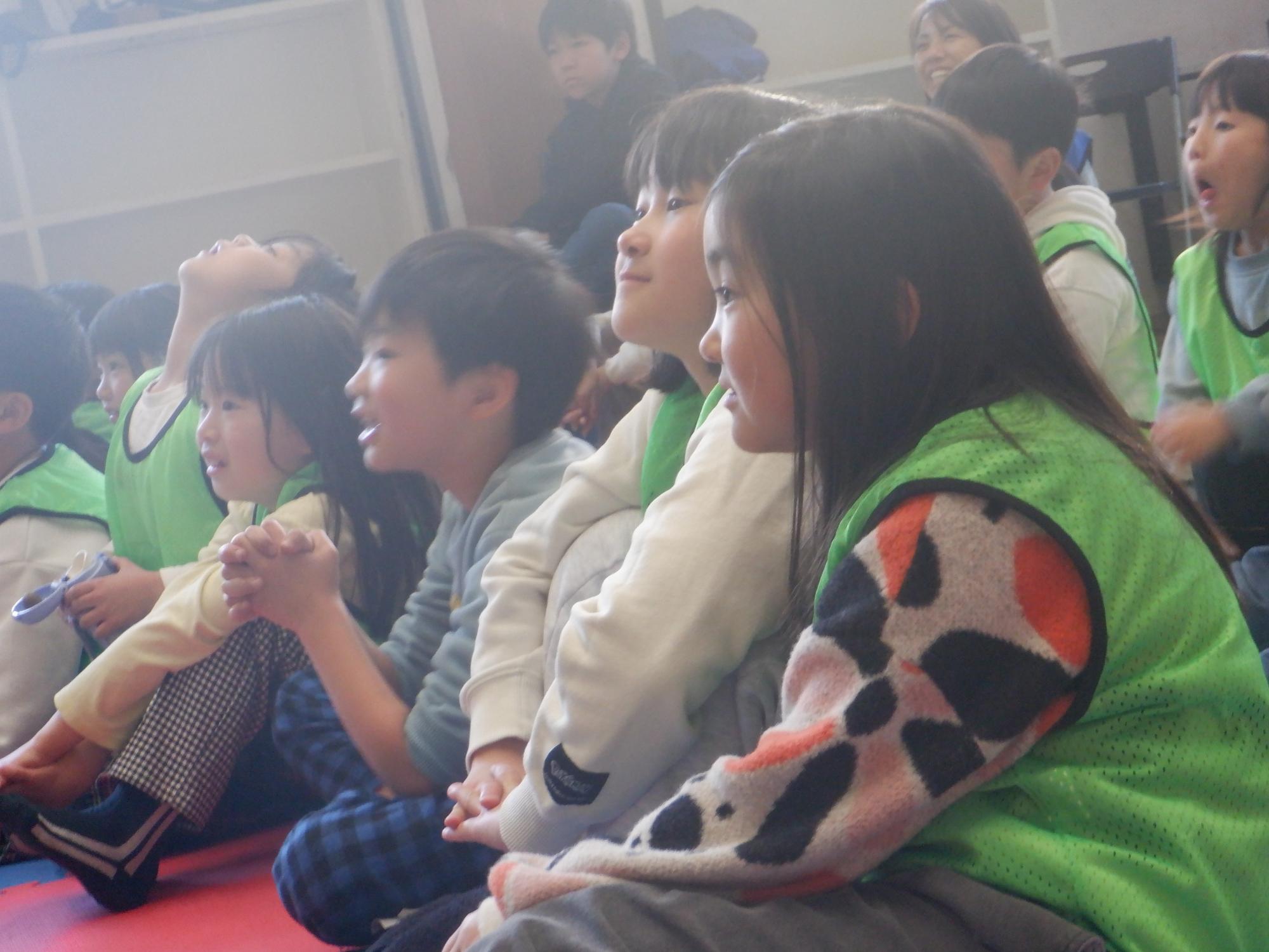 楽しそうに歌を聞く小学生