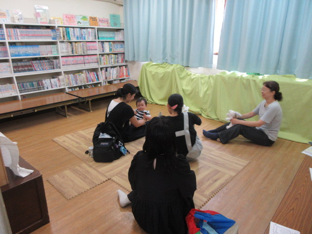 たまちゃんが幼児親子に読み聞かせをおこなっている様子の写真