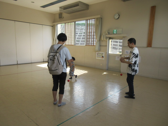 講師が幼児親子にけん玉を指導している写真