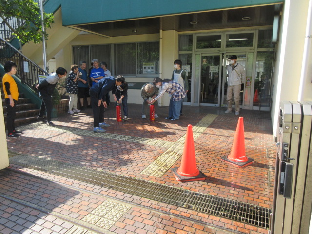 水消火器を使う様子見る参加者たち