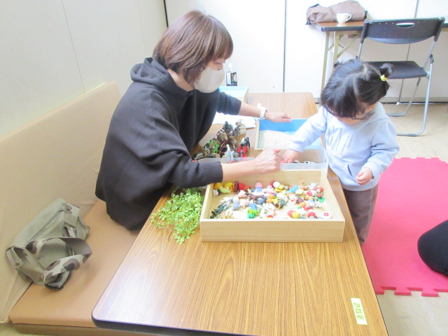 幼児がはこにわアートを楽しみながら先生からアドバイスをもらっている様子