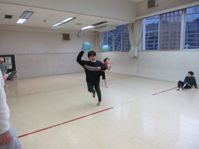 2人の男の子が笑顔でボールを投げている写真