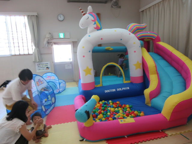 幼児親子が大型エアー遊具で遊ぶ様子の写真