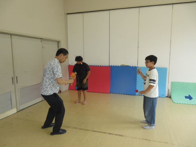 けん玉を教えてもらっている写真