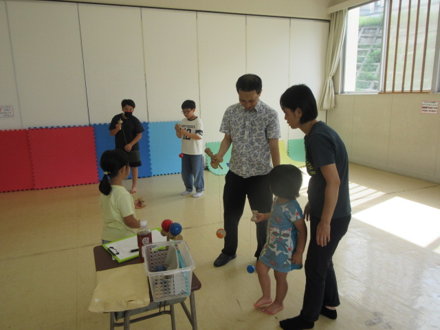 けん玉を教えてもらっている写真