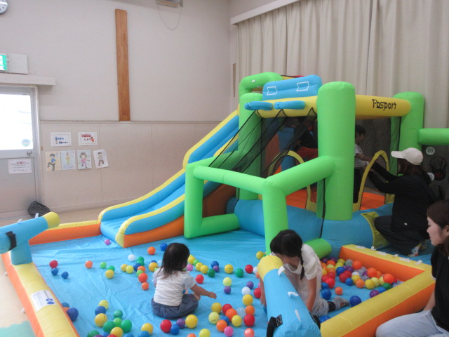 大型エアー遊具であそぶこどもたちの写真