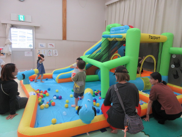 大型エアー遊具であそぶこどもたちの写真
