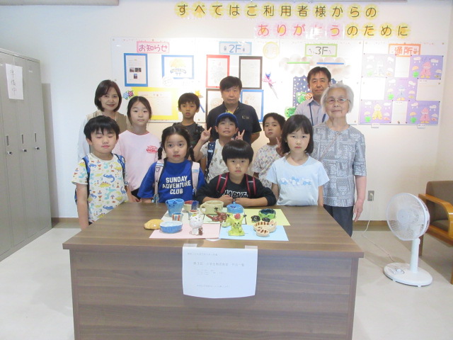 完成した作品とこどもたちとの集合写真