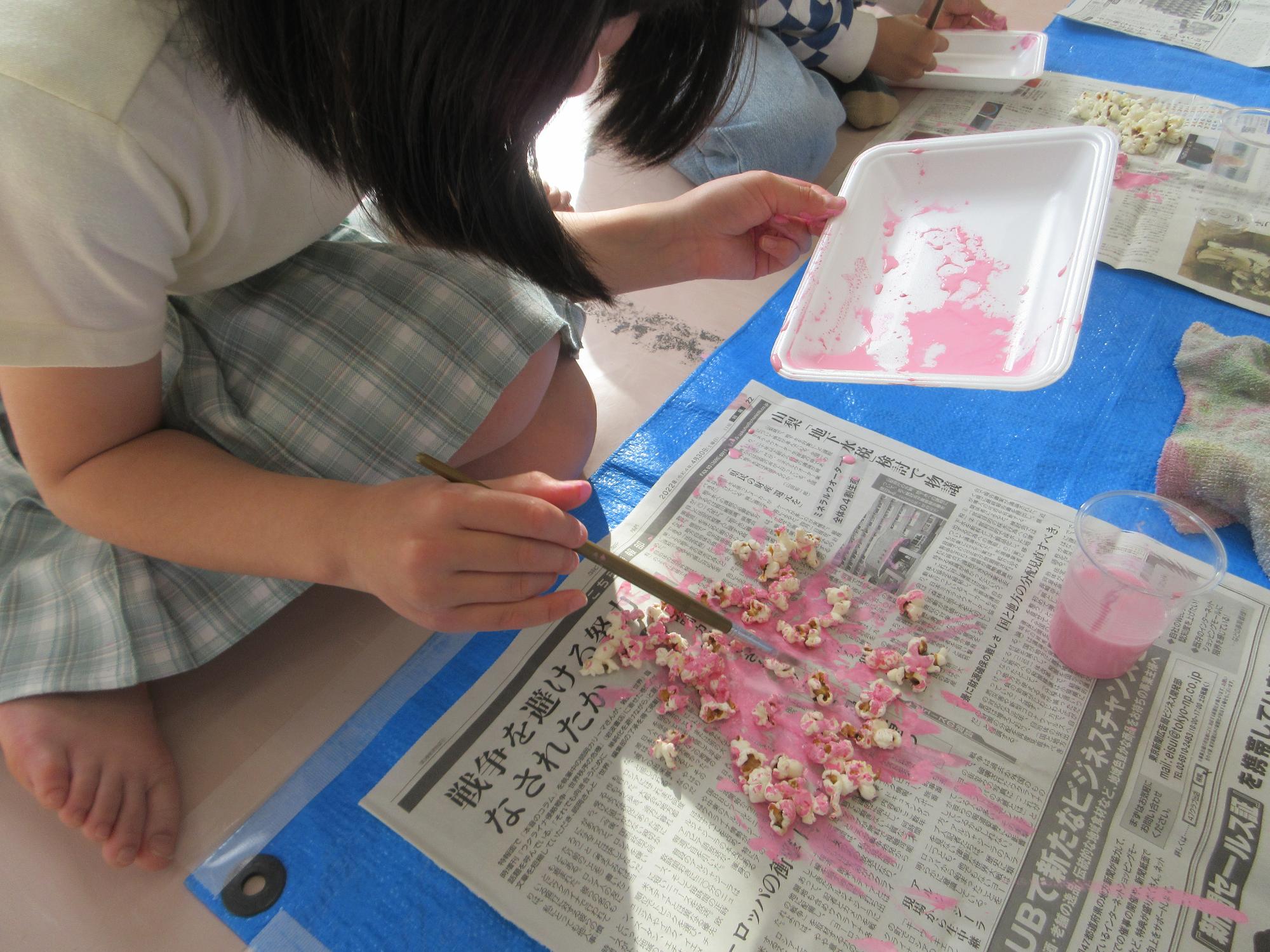 ポップコーンに色を付けている様子