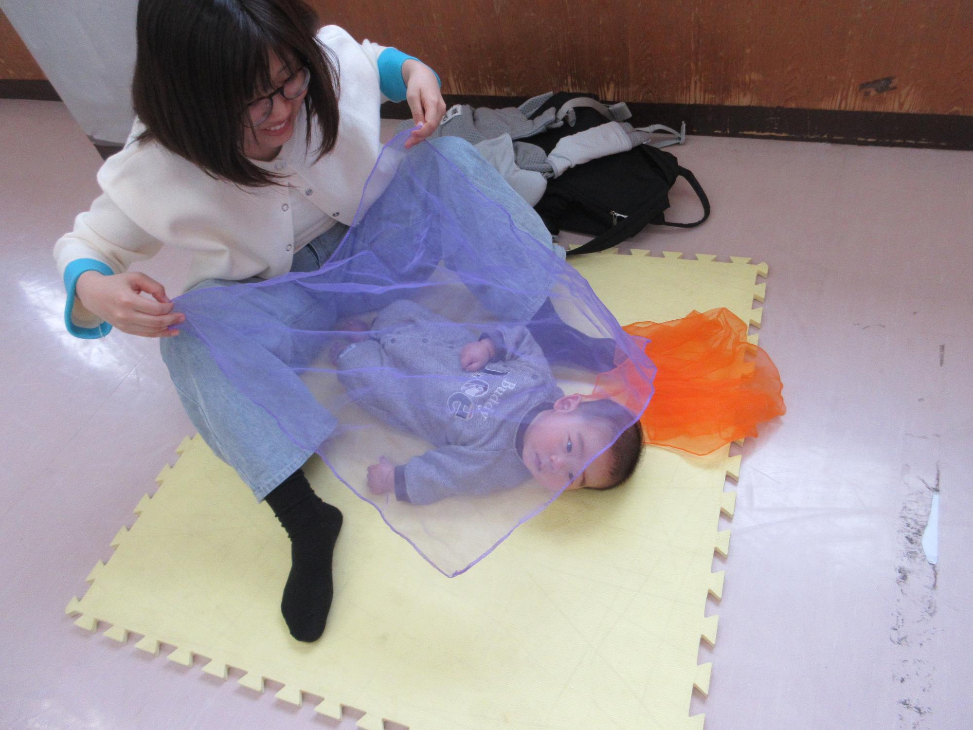 スカーフで遊ぶこどもの写真