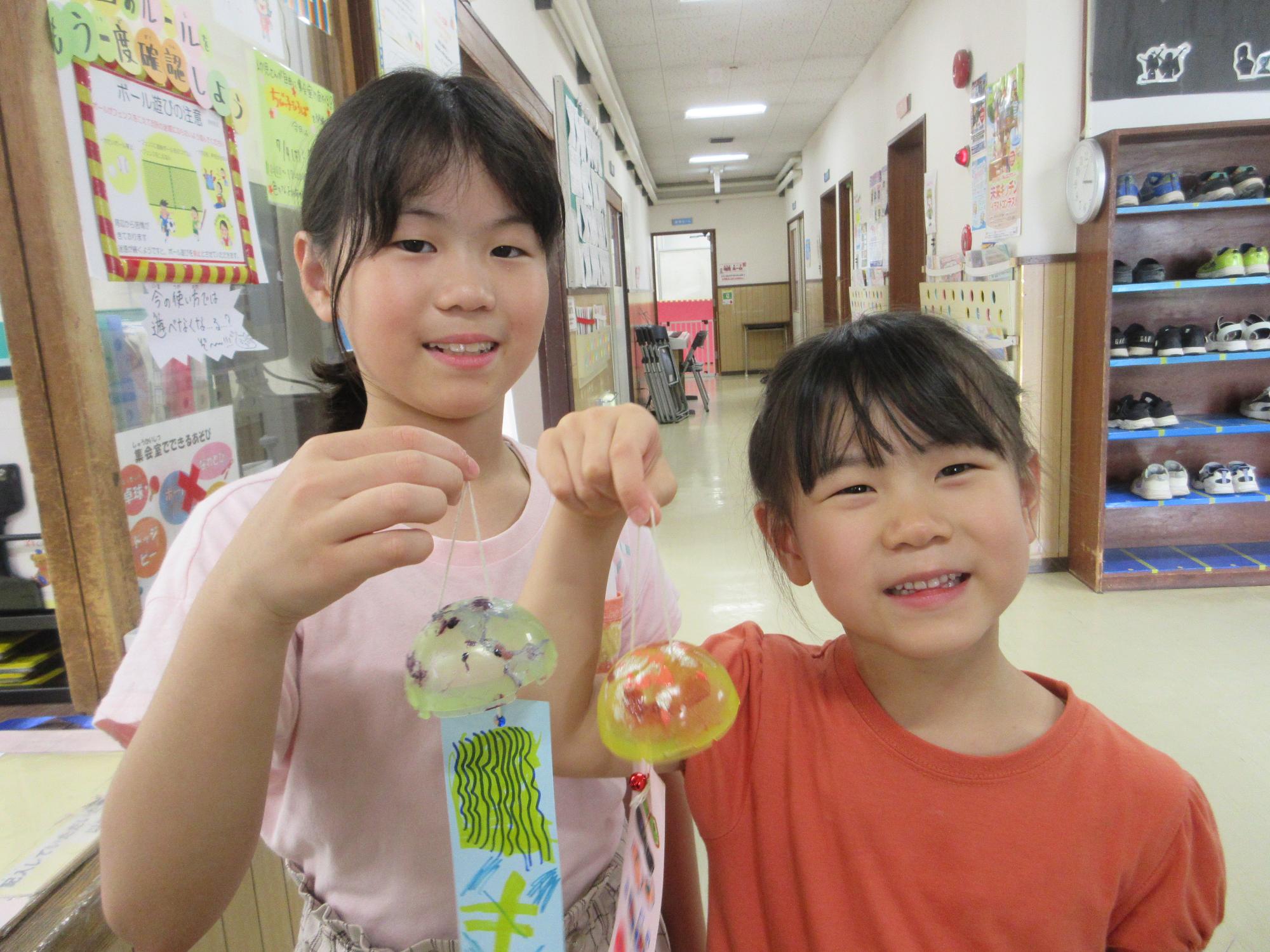 出来上がった風鈴をもって見せる笑顔の子どもたちのようす