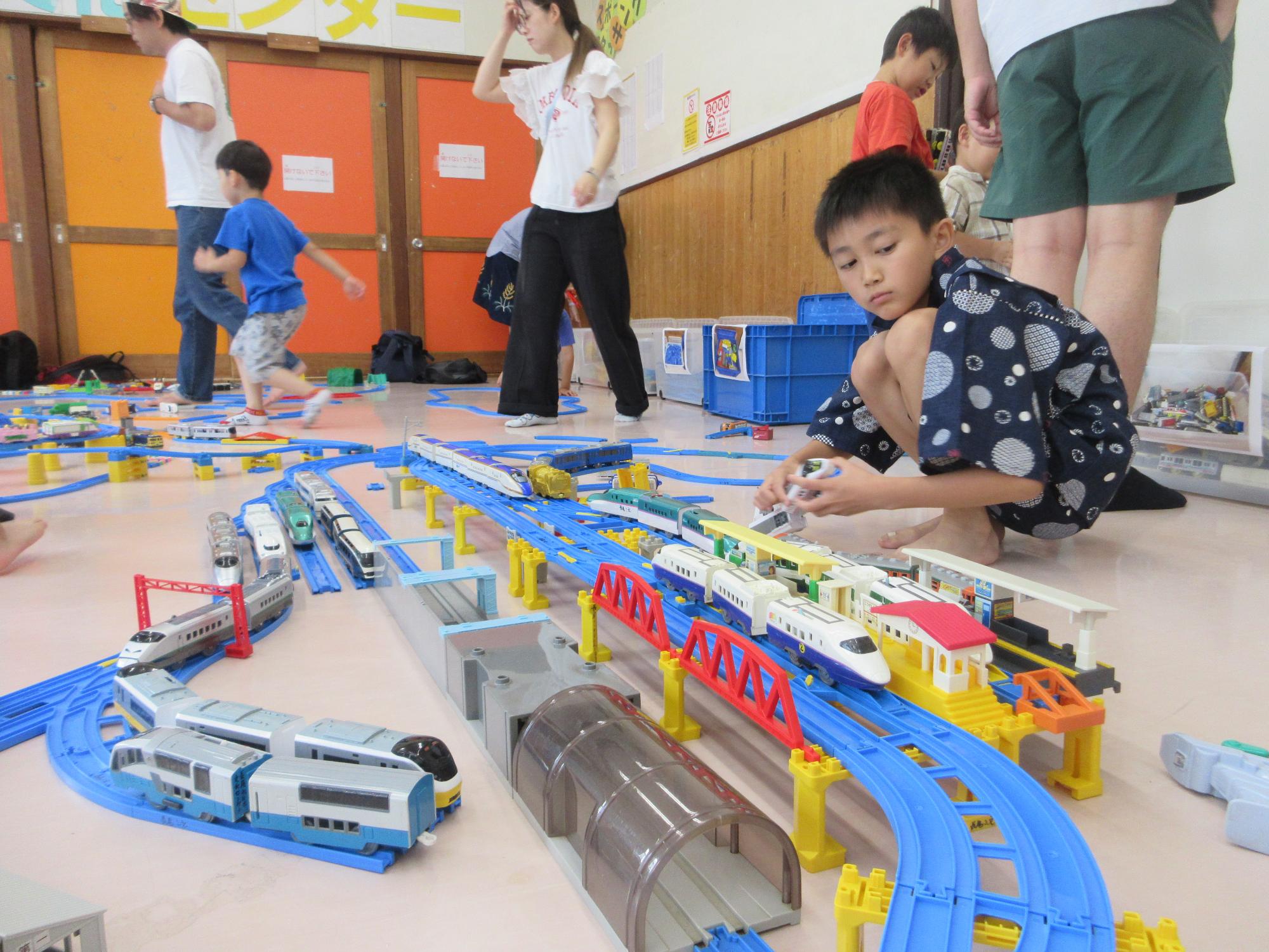 組みあげた線路に車両を走らせる子どものようす