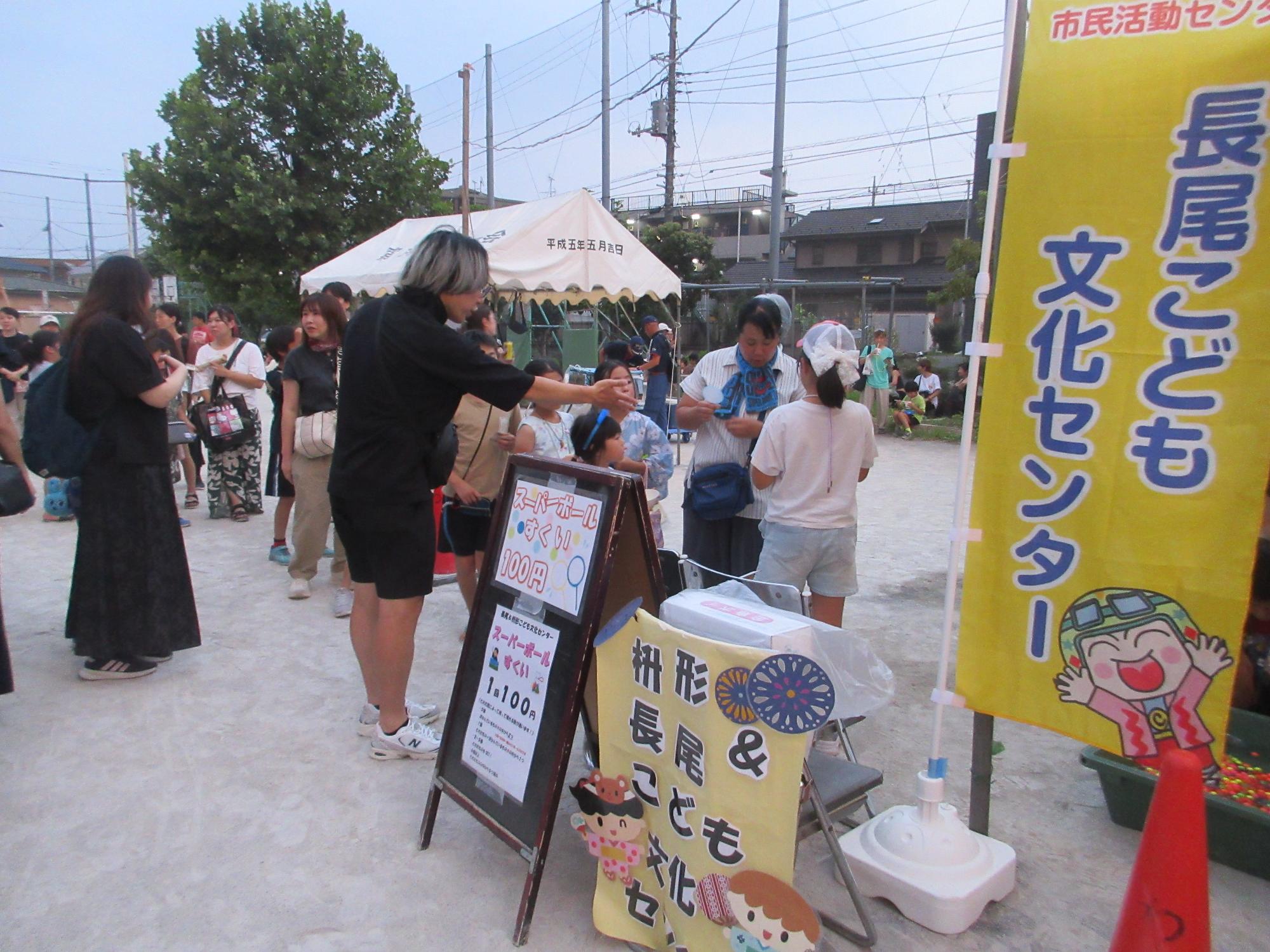 お祭りのスーパーボールすくいに並ぶ人たちの列