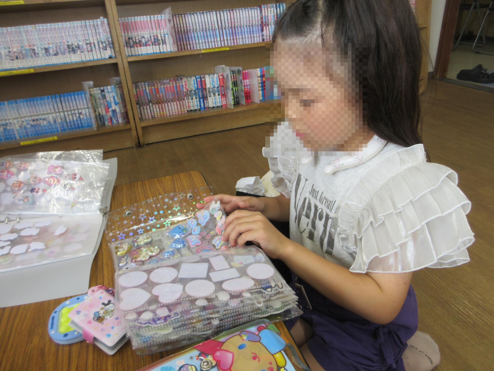 交換するシールをファイルから真剣に選ぶ児童のようす