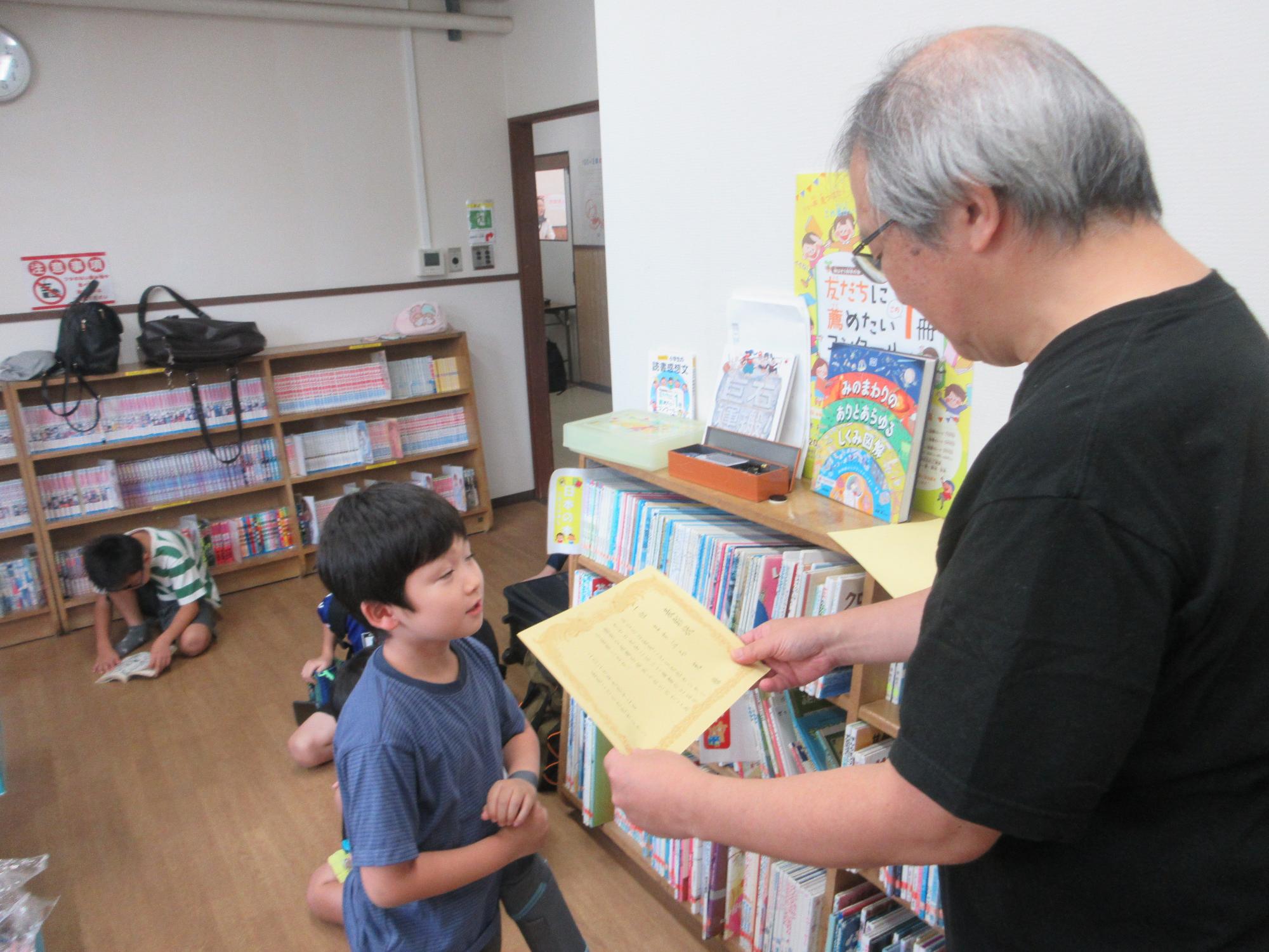 成績優秀者が先生に表彰される様子