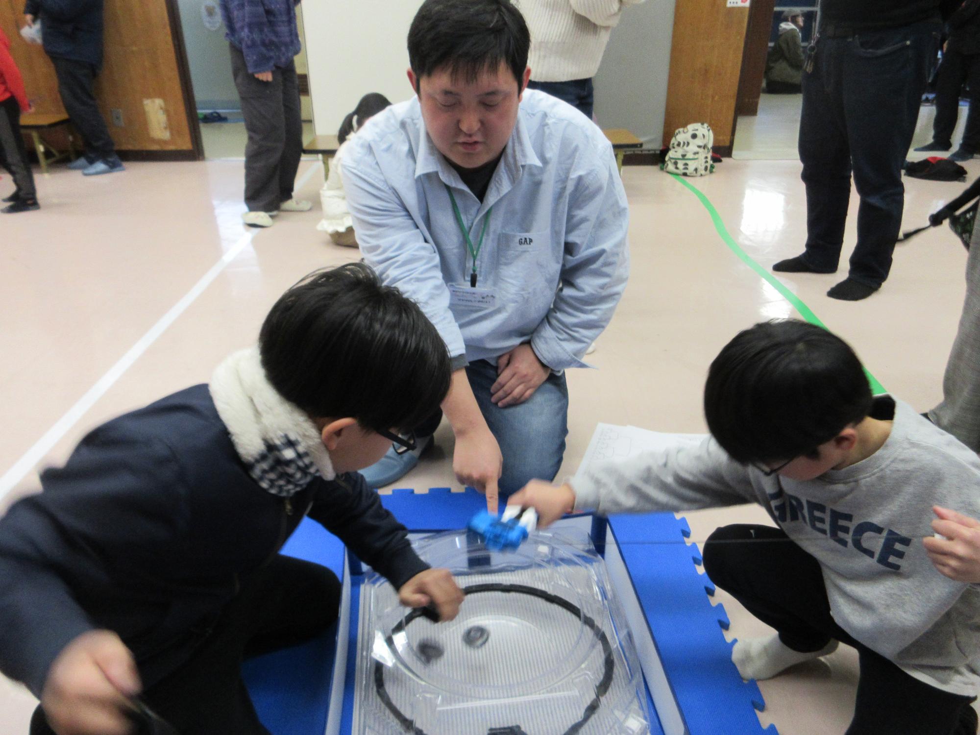 ベイブレードをする子どもたちの写真