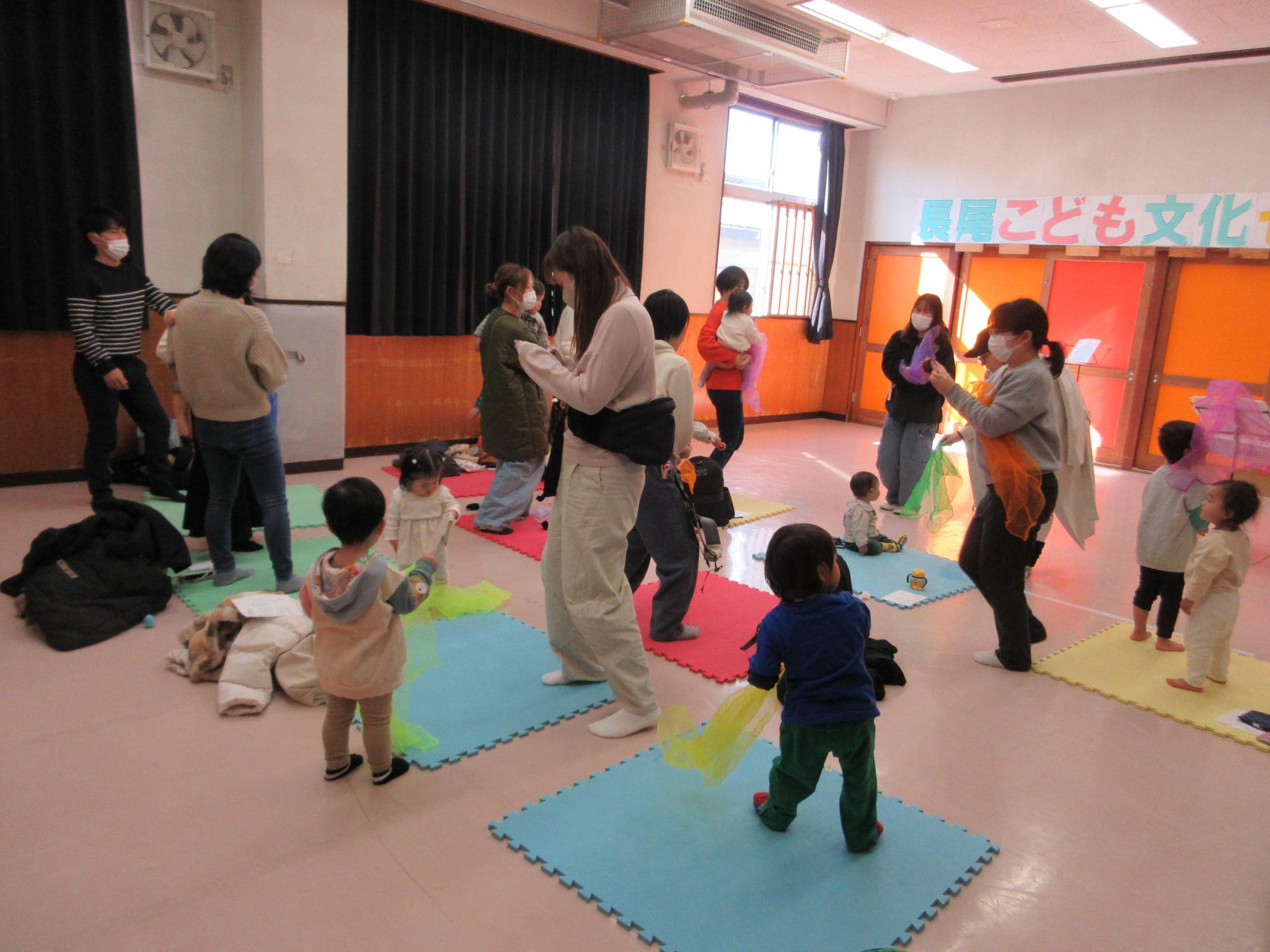 スカーフで遊ぶ子どもたちの写真
