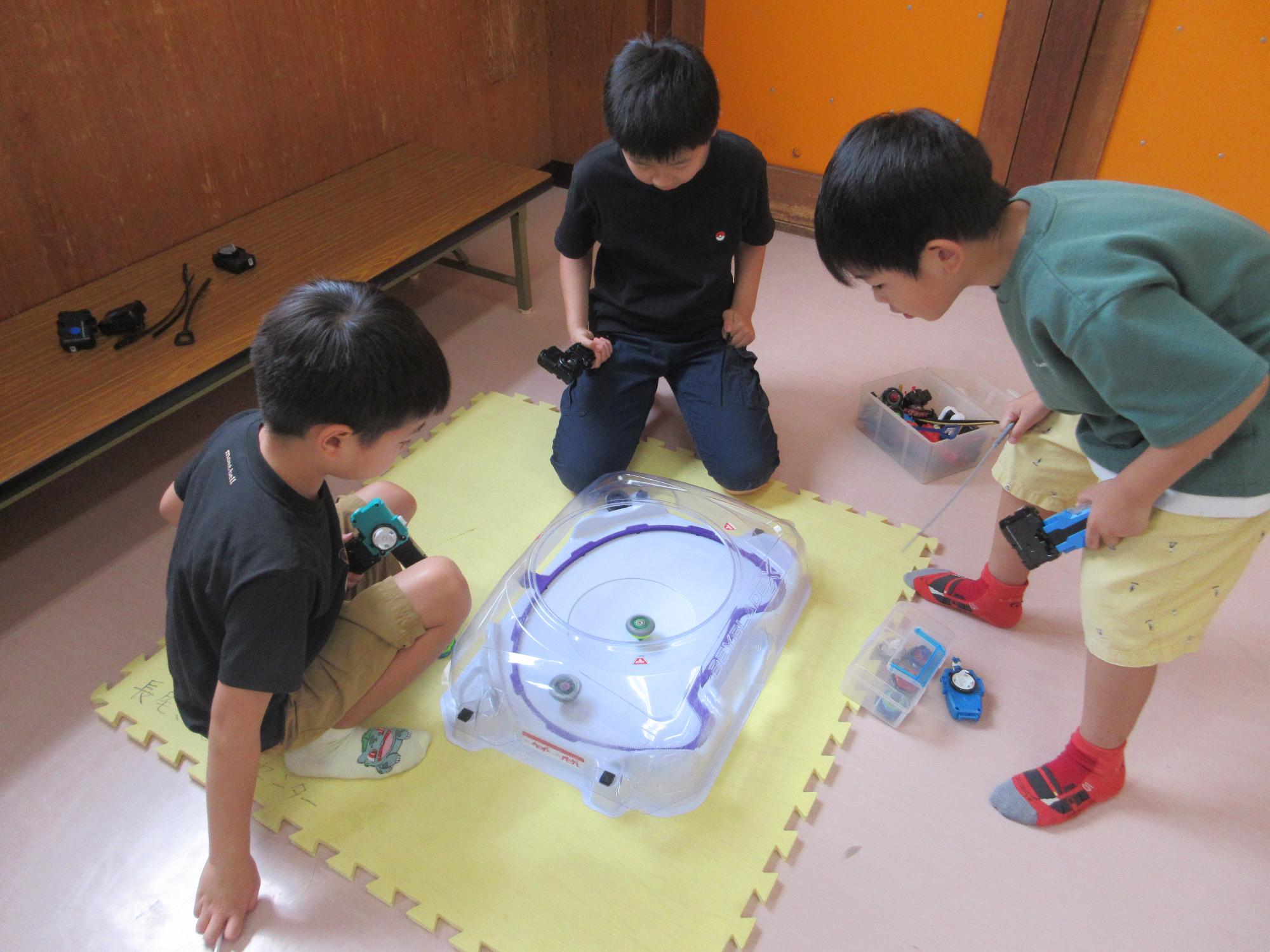 ベイブレードをする子どもたちの写真