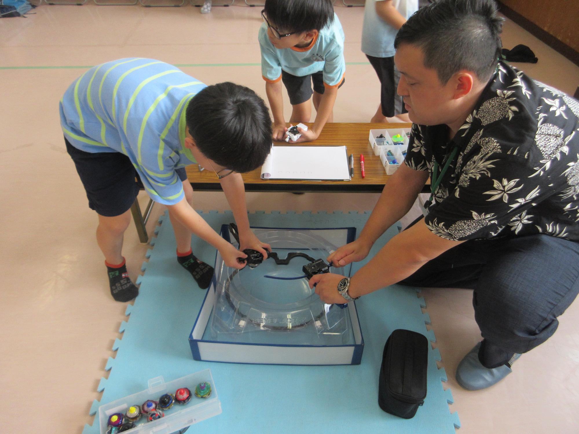 ベイブレードをする子どもたちの写真